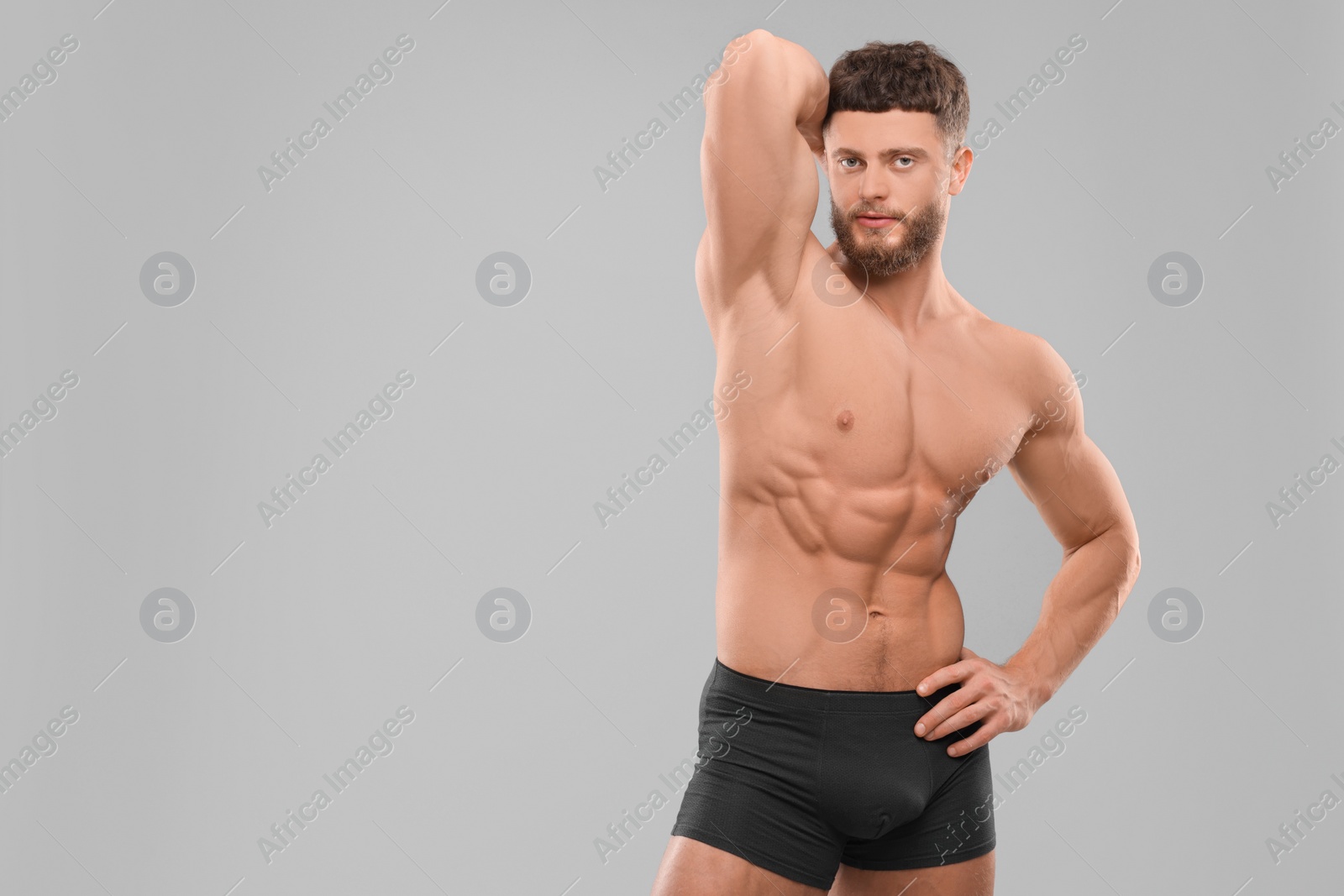 Photo of Handsome muscular man on light grey background, space for text. Sexy body