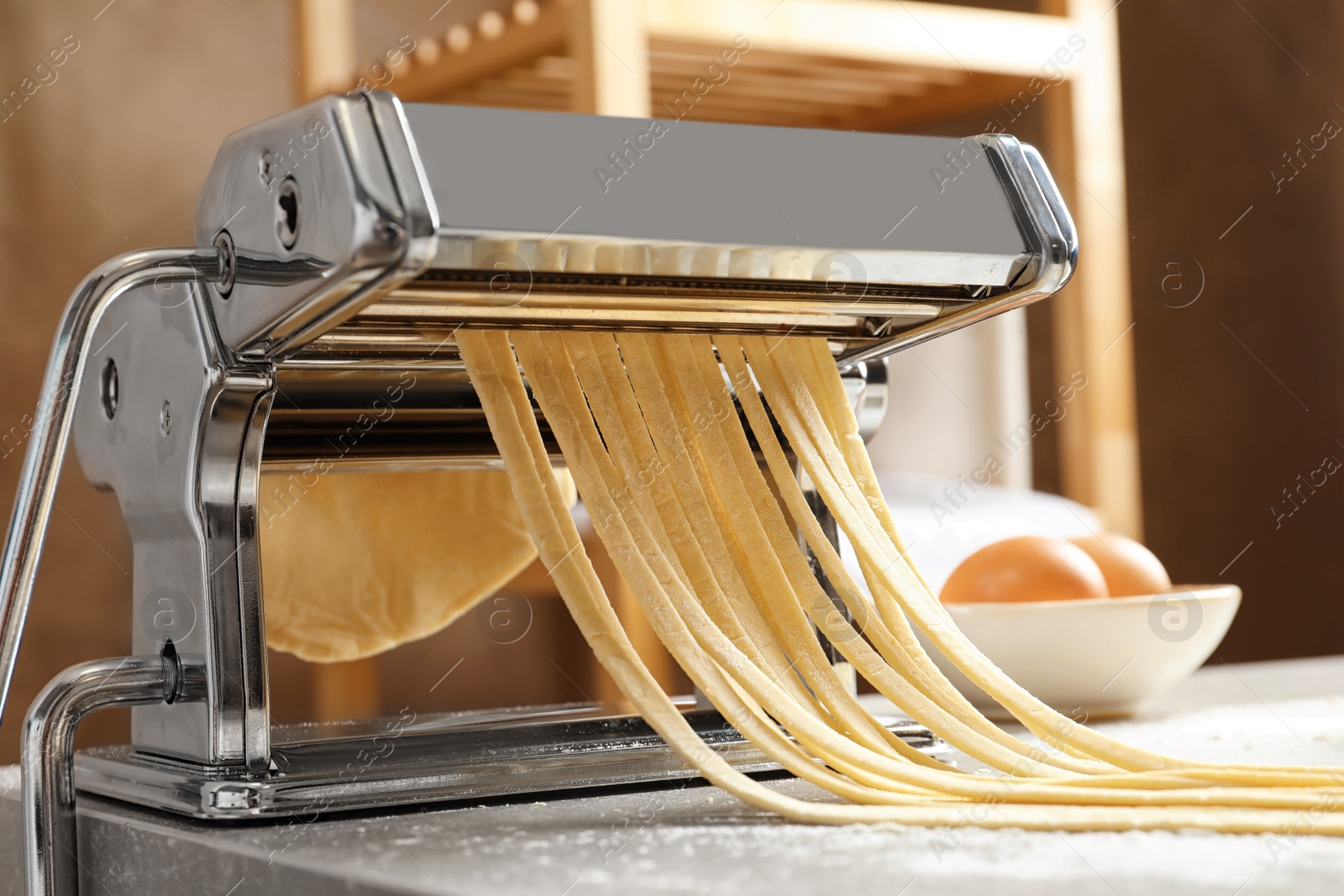 Photo of Pasta maker with dough on kitchen table