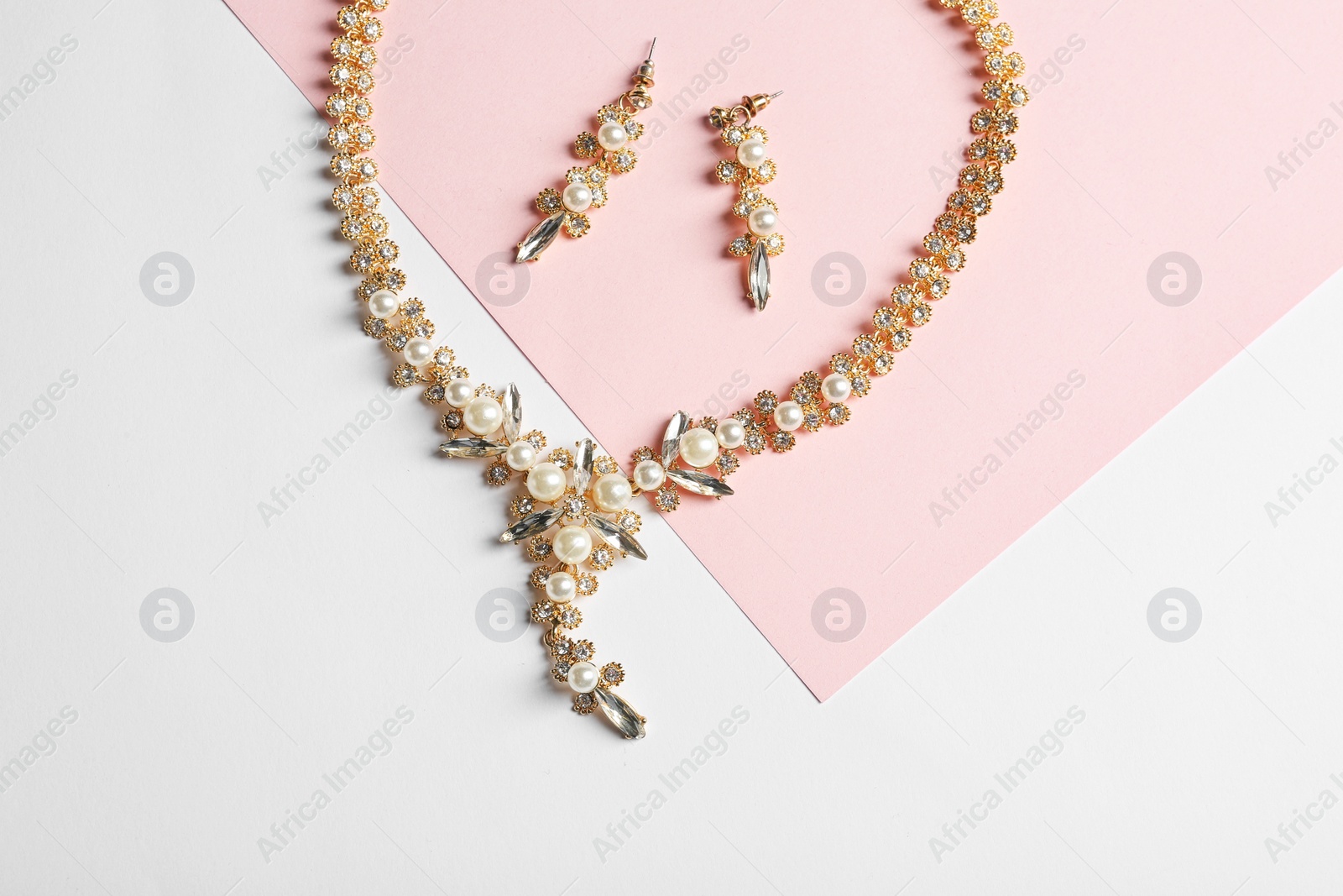 Photo of Set of elegant jewelry on color background, top view