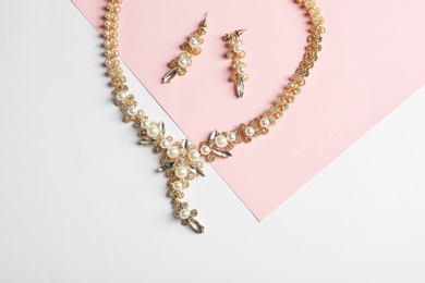 Photo of Set of elegant jewelry on color background, top view