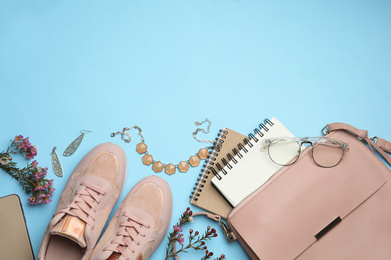 Flat lay composition with stylish woman's bag and accessories on light blue background. Space for text