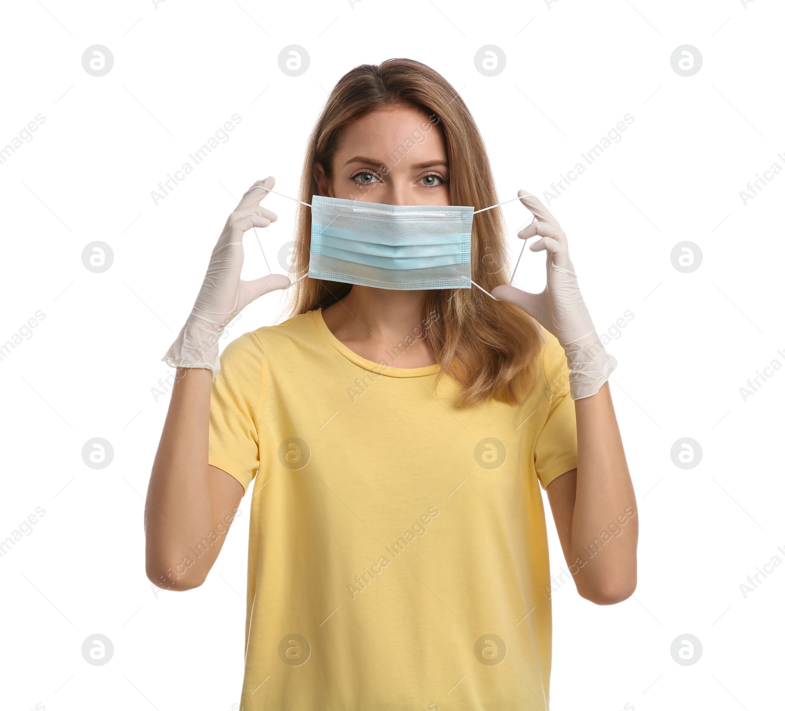 Photo of Woman in medical gloves putting on protective face mask against white background