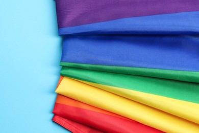 Rainbow LGBT flag on light blue background, top view