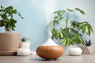 Photo of Composition with modern essential oil diffuser on table against blue background, space for text