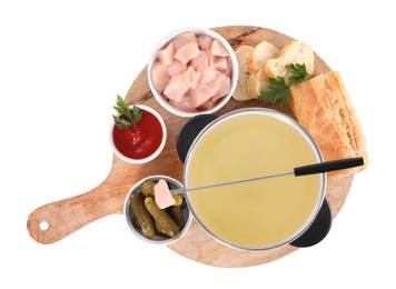 Photo of Oil in fondue pot, fork, pieces of raw meat and other products isolated on white, top view
