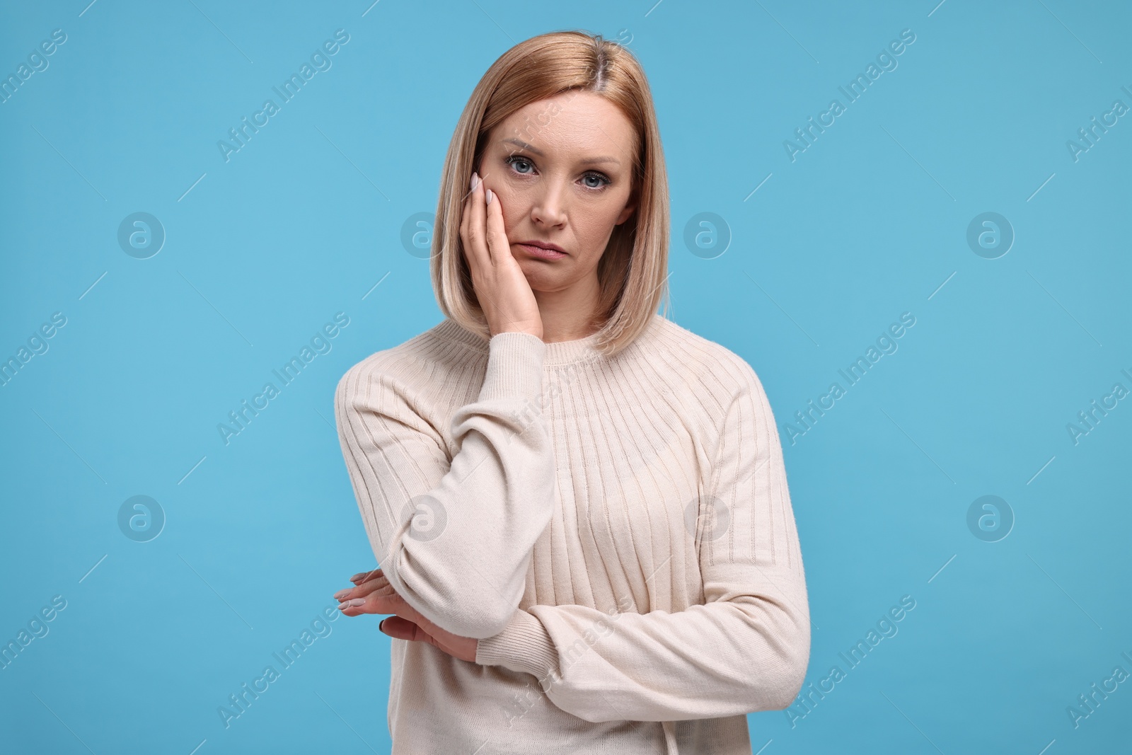 Photo of Portrait of sad woman on light blue background