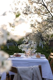 Photo of Stylish table setting with beautiful spring flowers in garden