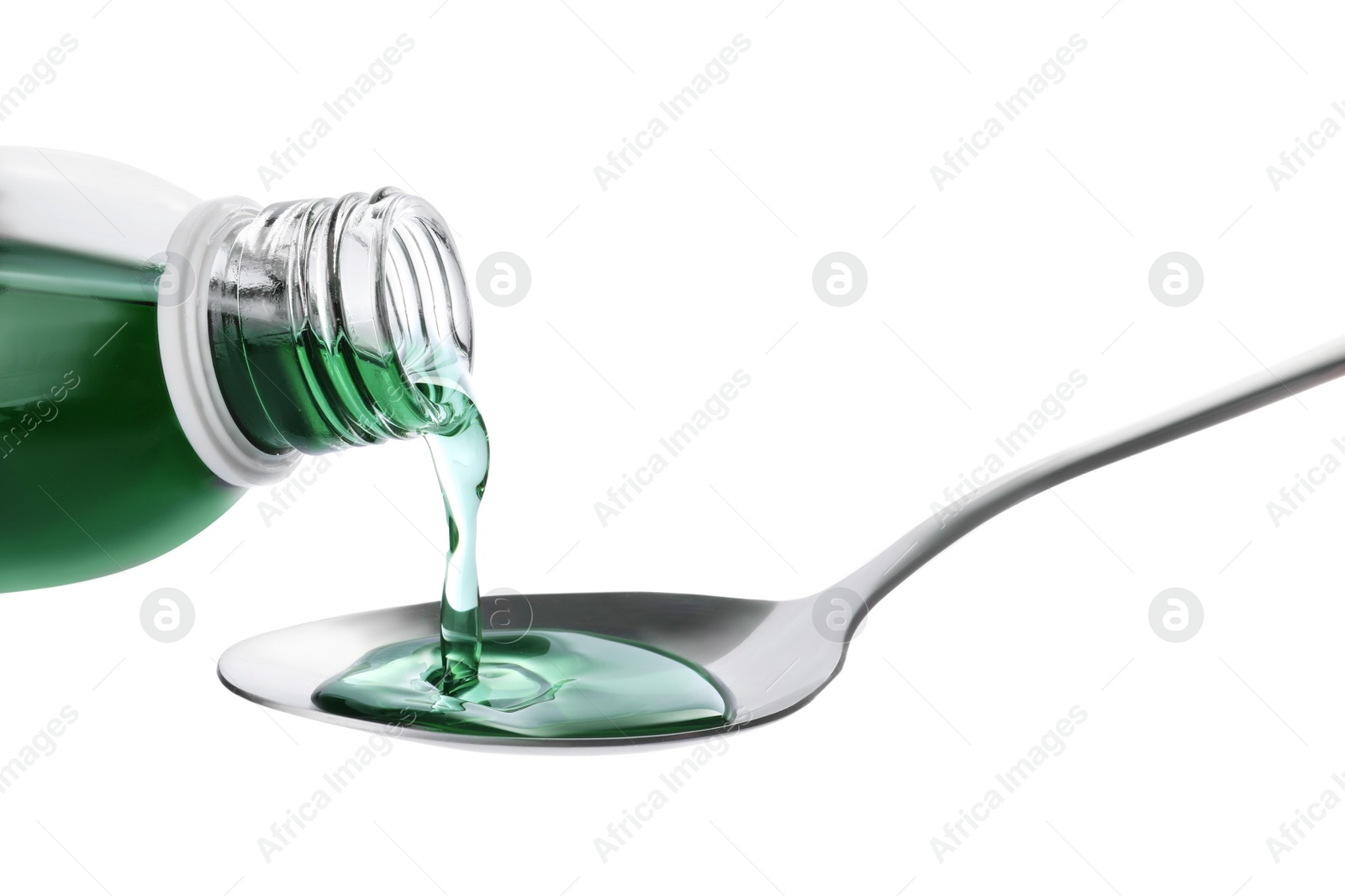 Photo of Pouring syrup into spoon from bottle isolated on white, closeup. Cough and cold medicine