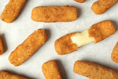 Photo of Tasty cheese sticks on grey background, top view