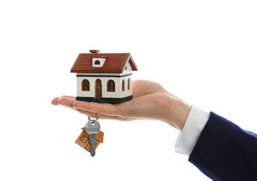 Photo of Real estate agent holding house model and key on white background, closeup