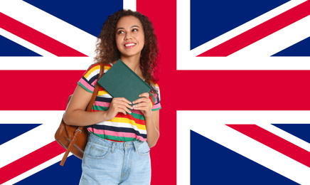 Beautiful African-American girl with book and flag of Great Britain as background. Learning English