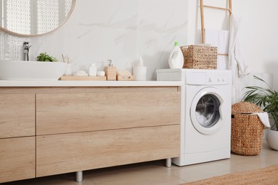 Photo of Stylish bathroom interior with modern washing machine