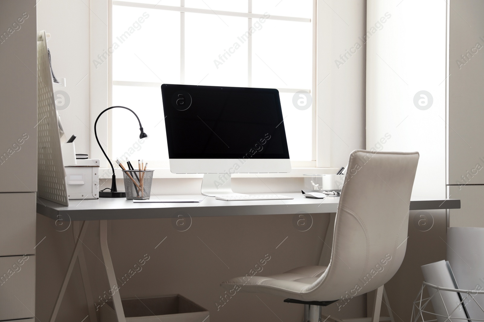 Photo of Light work place with computer near window. Interior design