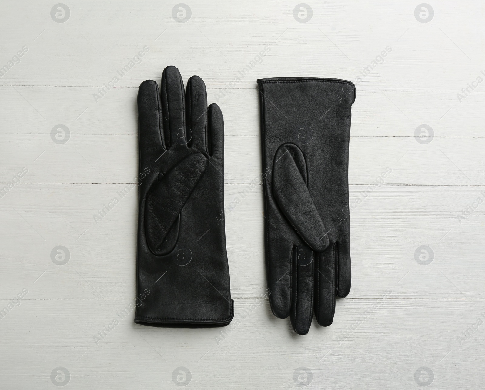 Photo of Pair of stylish leather gloves on white wooden background, flat lay