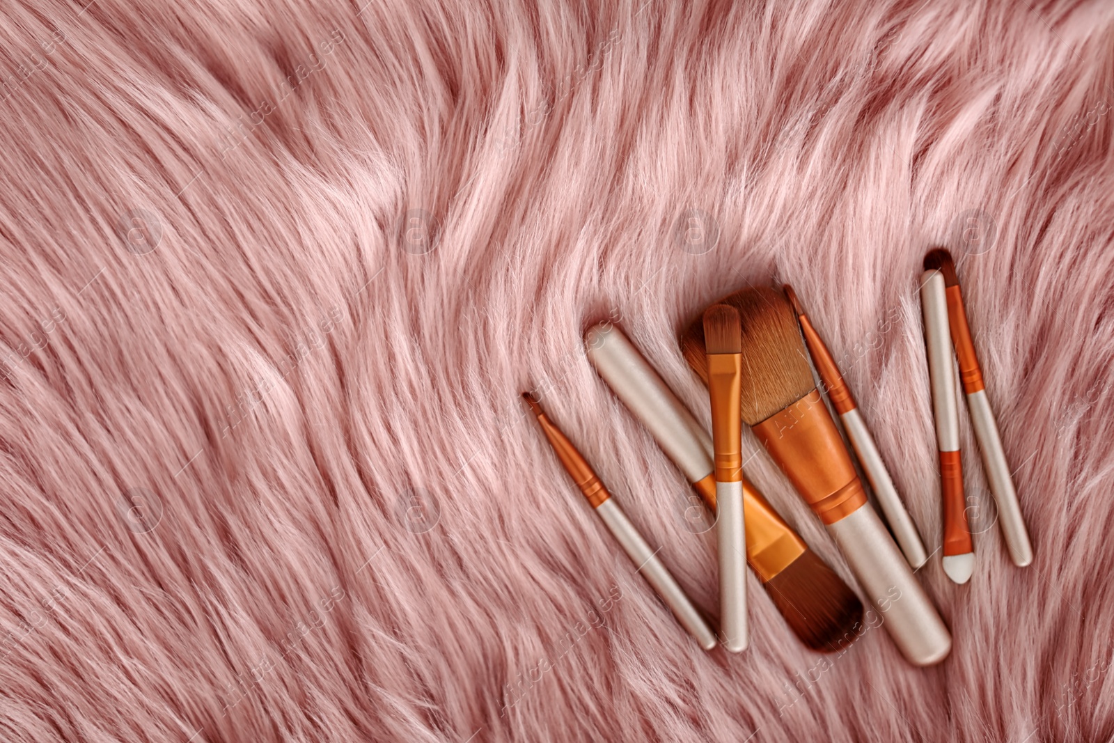 Photo of Flat lay composition with makeup brushes on faux fur