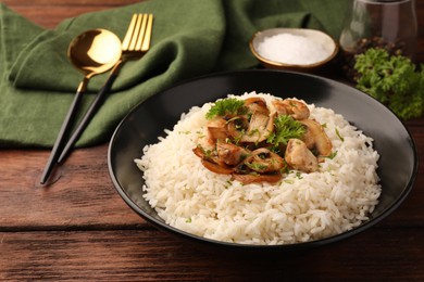 Photo of Delicious rice with mushrooms and parsley served on wooden table