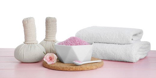Composition with sea salt and herbal bags on pink wooden table against white background
