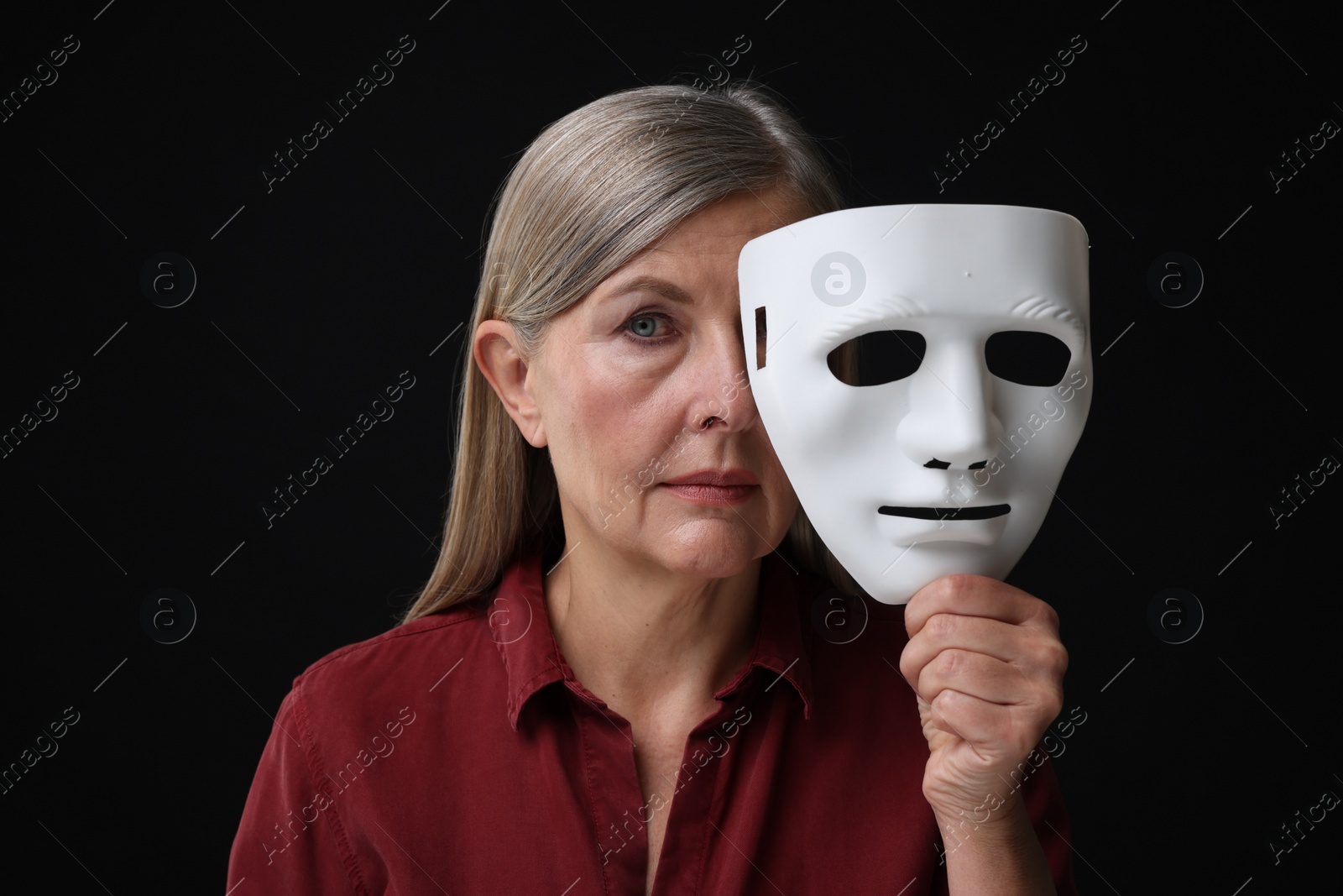 Photo of Multiple personality concept. Woman with mask on black background