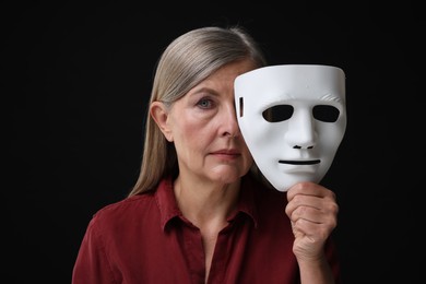 Photo of Multiple personality concept. Woman with mask on black background