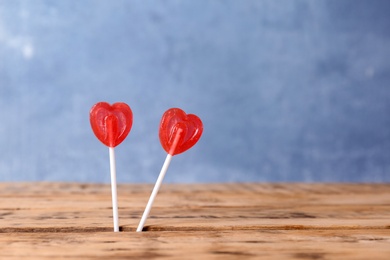 Photo of Heart shaped lollipops on color background, space for text. Sweet love