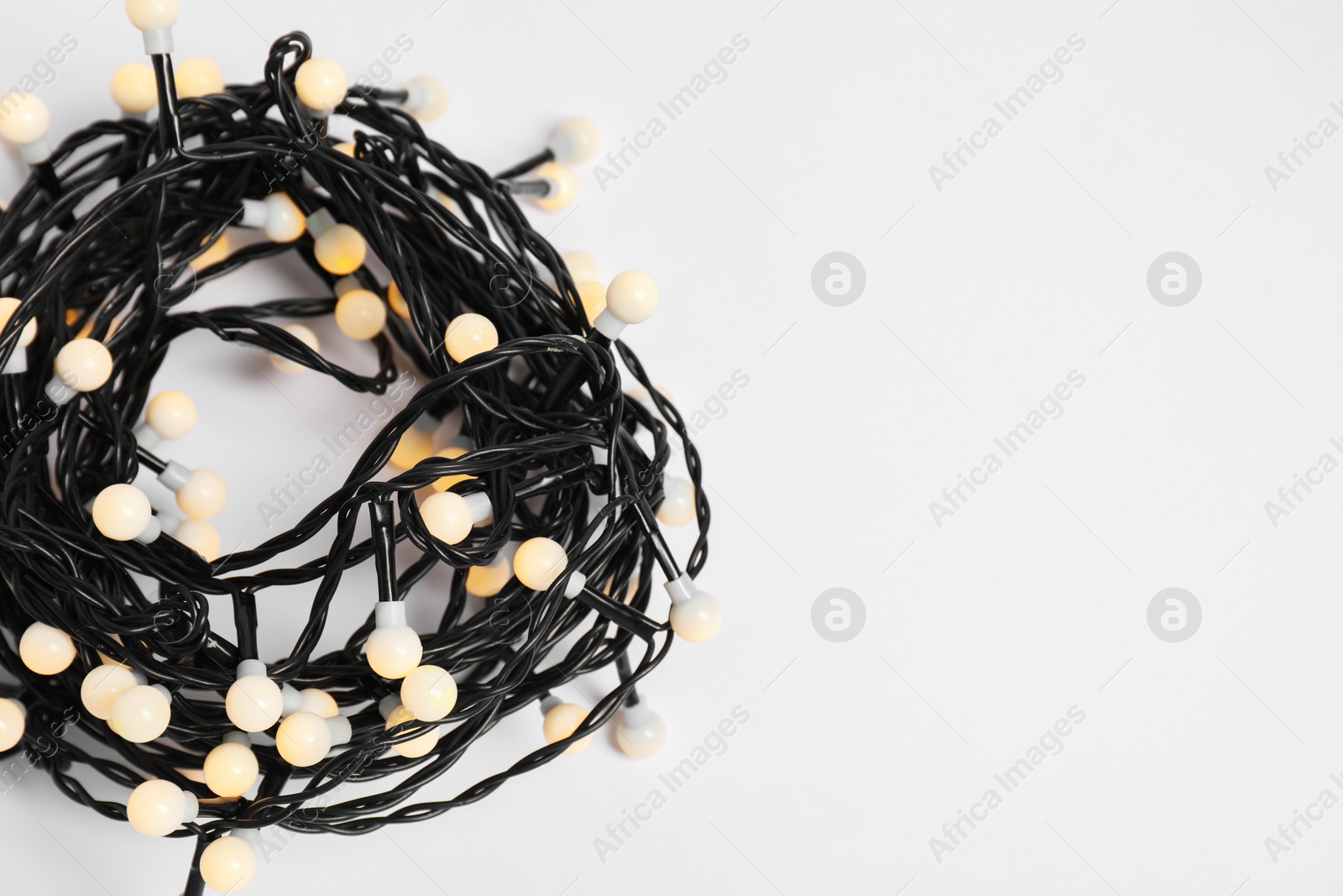 Photo of Beautiful Christmas lights on white background, top view