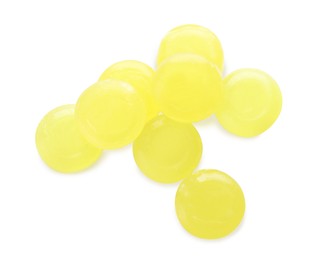 Photo of Many yellow cough drops on white background, top view