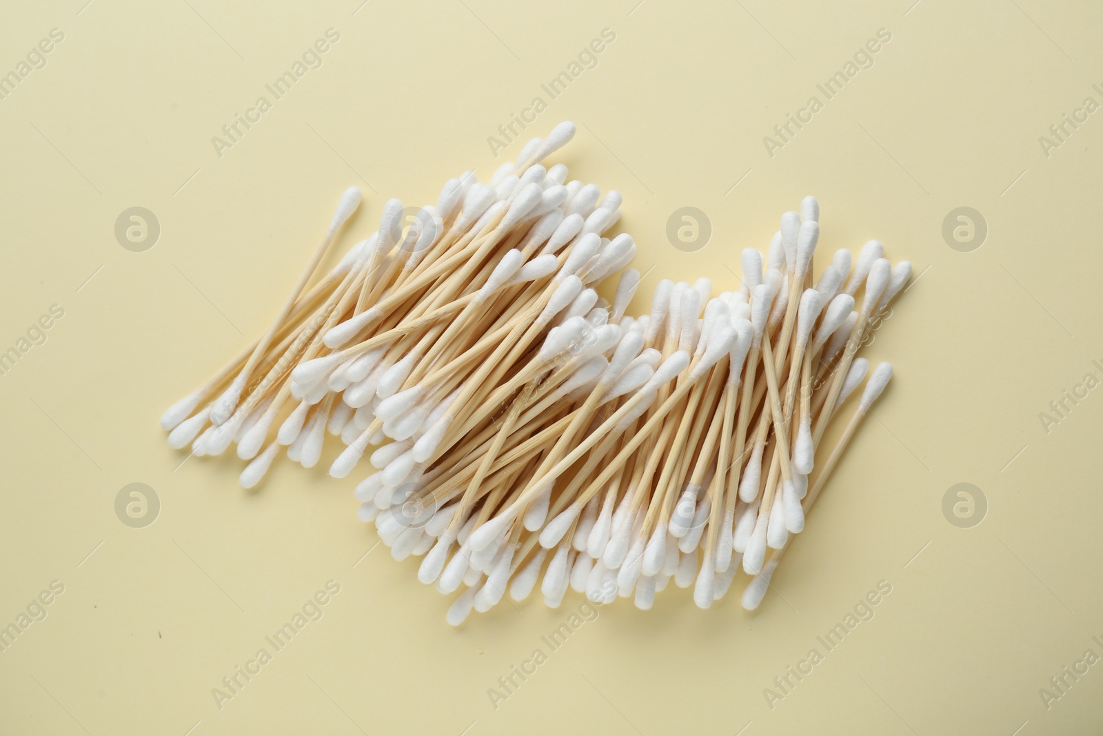 Photo of Heap of wooden cotton buds on beige background, flat lay