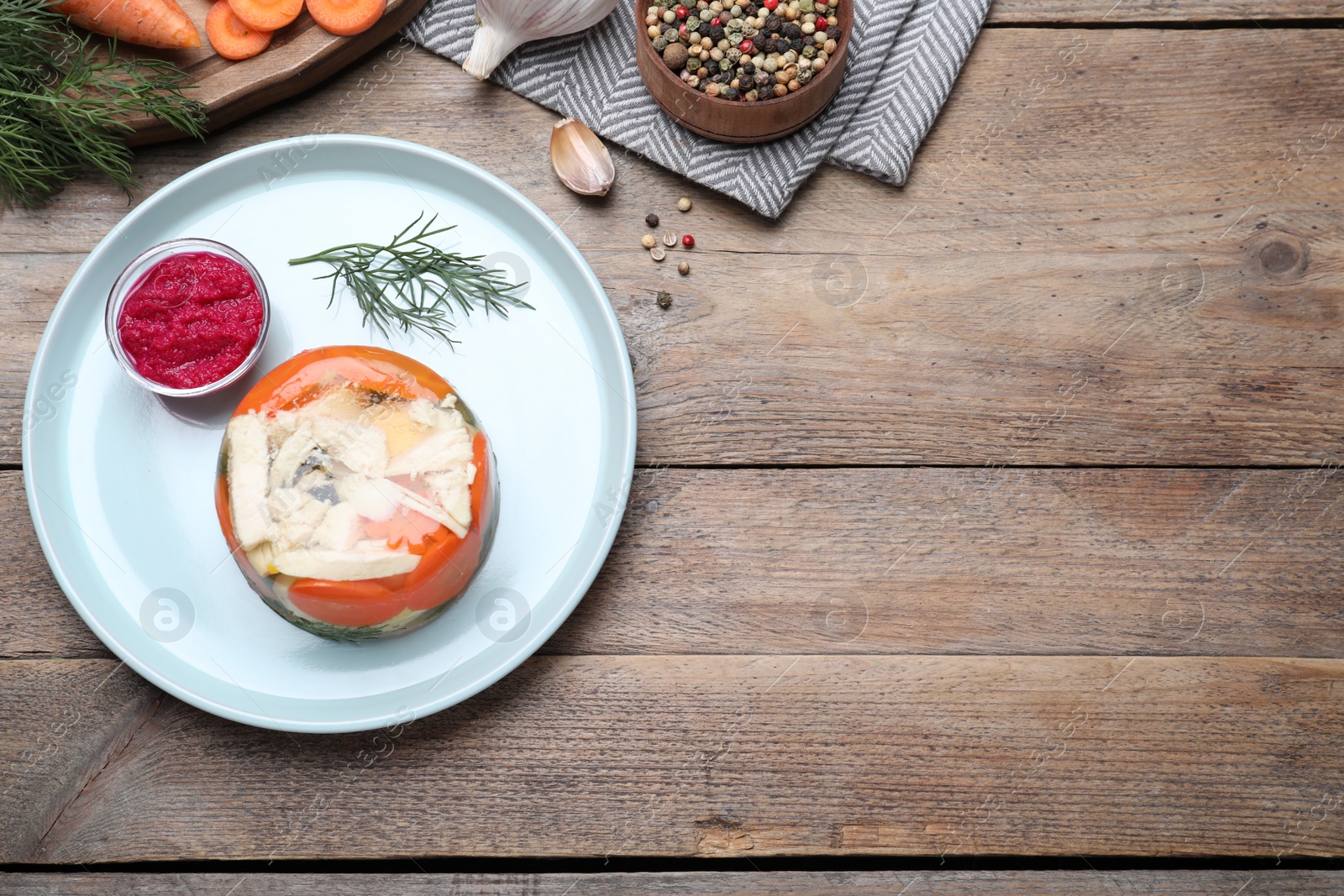 Photo of Delicious chicken aspic served on wooden table, flat lay. Space for text