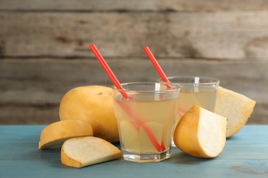 Photo of Glasses of freshly made turnip juice on turquoise wooden table