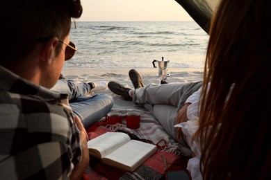 Couple resting in camping tent near sea