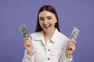 Happy woman with dollar banknotes on purple background