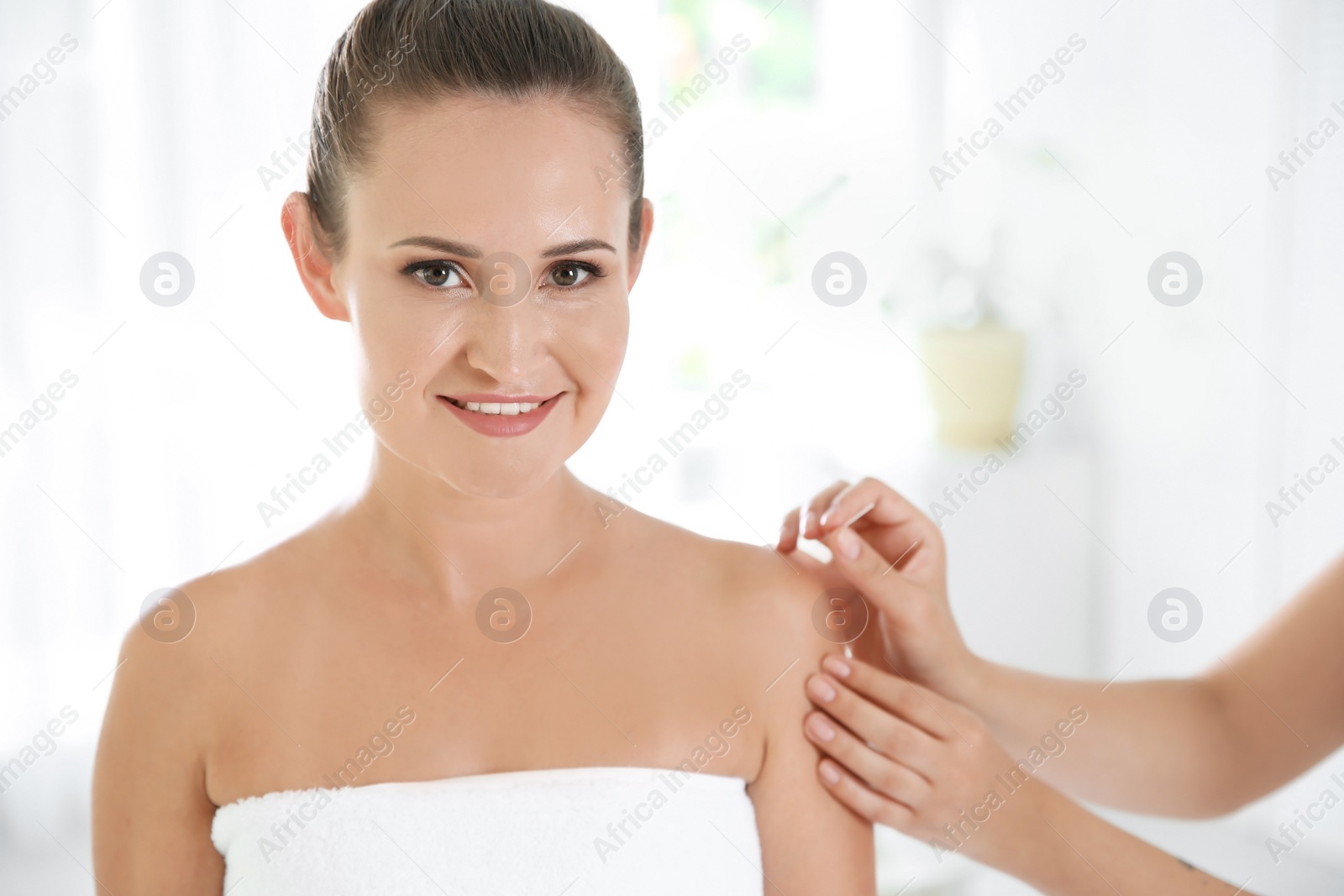 Photo of Young woman undergoing acupuncture treatment in salon