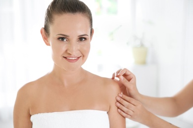 Young woman undergoing acupuncture treatment in salon