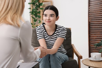 Psychologist working with teenage girl in office