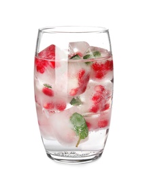Glass of drink with pomegranate ice cubes on white background