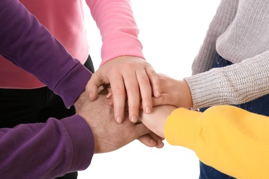 Photo of Group of people holding their hands together on white background, closeup