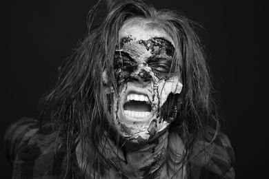 Scary zombie on dark background, black and white effect. Halloween monster