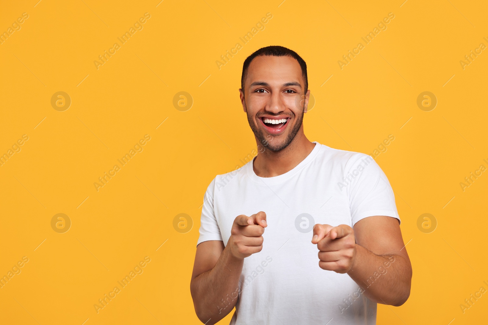Photo of Portrait of happy African American man on orange background. Space for text