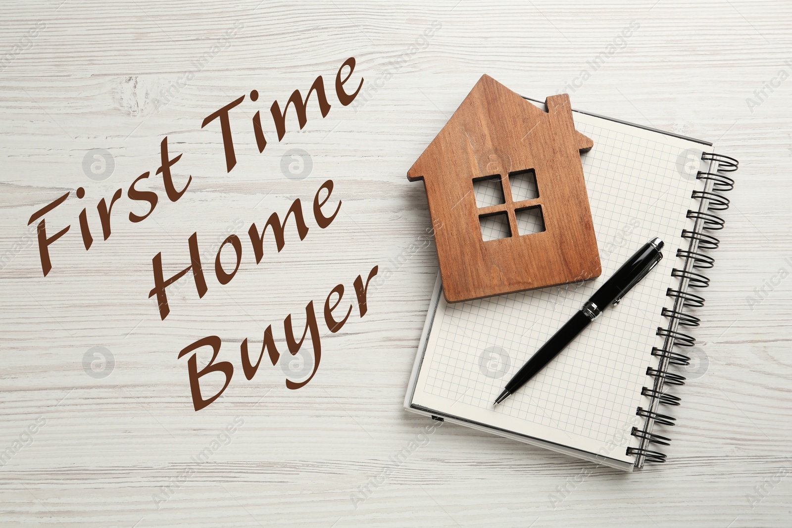 Image of First time home buyer. House figure, pen and notebook on white wooden table, top view