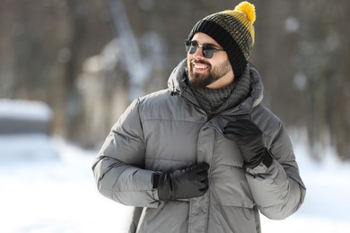 Photo of Portrait of handsome young man with sunglasses on winter day outdoors