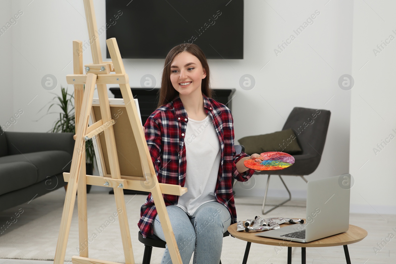 Photo of Woman learning to paint with online course at home. Time for hobby