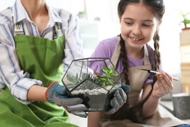 Mother and daughter taking care of plants at home