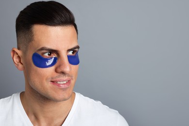 Photo of Man with blue under eye patches on grey background. Space for text