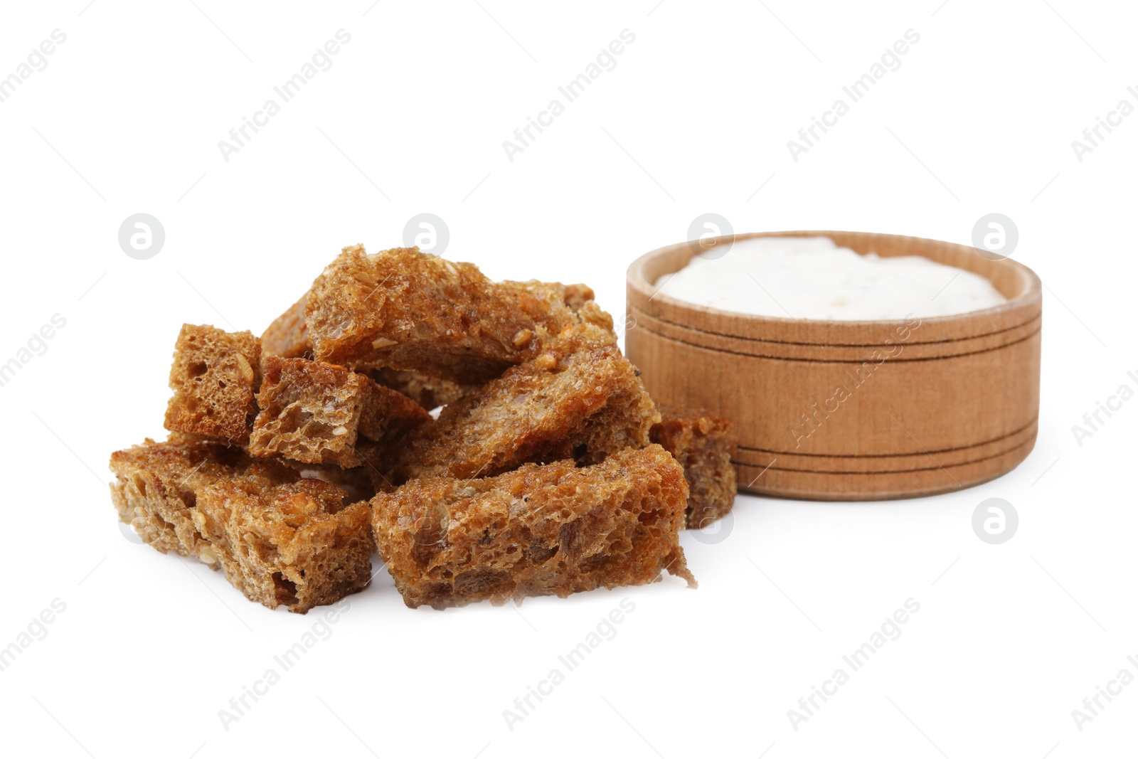 Photo of Heap of crispy rusks and sauce isolated on white