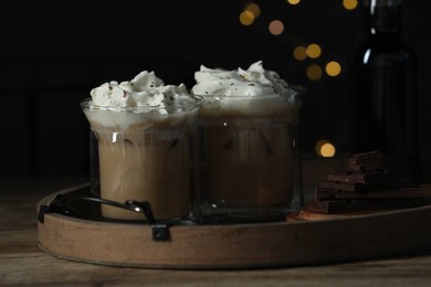 Photo of Glasses of iced coffee and chocolate against blurred lights