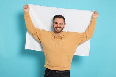 Man with blank white flag on light blue background