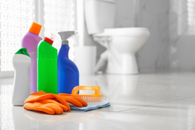 Cleaning supplies and toilet bowl in bathroom. Space for text