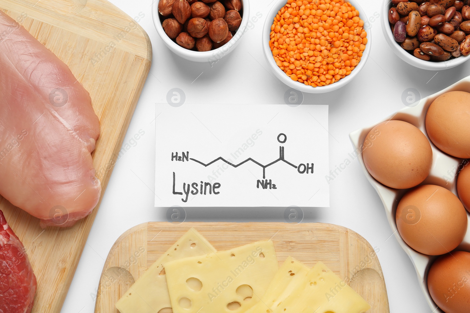 Photo of Different fresh products and paper with Lysine chemical formula on white background, top view. Sources of essential amino acids
