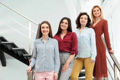 Photo of Portrait of happy ladies on stairs indoors. Women power concept