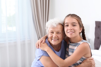 Photo of Happy cute girl with her grandmother at home